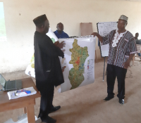 lift to right foya district paramount chief momoh taylor and lofa county assistant superintendent for development hon. moses sonjor hold up the man of foya in display to the audience.jpg