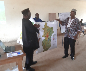 lift to right foya district paramount chief momoh taylor and lofa county assistant superintendent for development hon. moses sonjor hold up the man of foya in display to the audience.jpg